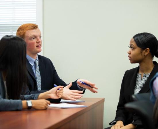 Students in business attire having a discussion