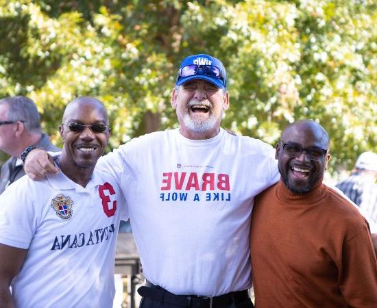 Three men smiling together outside